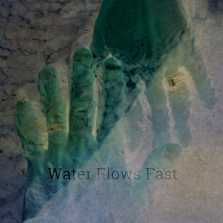 Stylized photo of two hands touching underwater with prominently gleaming wedding bands.